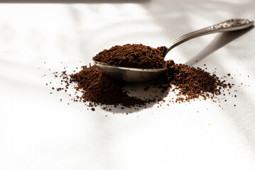 Old spoon with ground coffee in sunlight, aroma of the beginning of the day