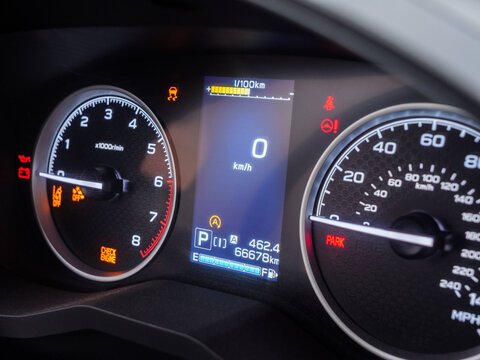Warning lights illuminating car dashboard, gauges displaying zero speed and critical vehicle information