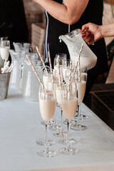 Copas con sorbete de piña colada y pajitas decoradas con corazones. Concepto de cóctel en boda o celebración al aire libre.
