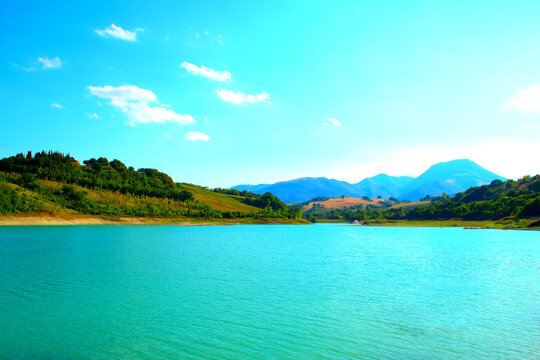 Relaxing view from Lago di Cingoli, the blue outlines of the majestic Sibillini Mountains are very visible in the distant background with the placid waters of Lago di Castreccioni lying in front