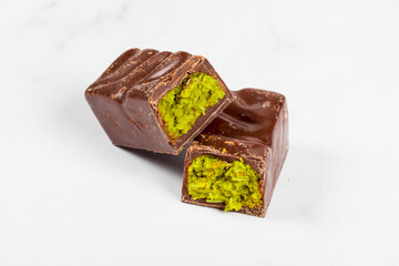Vegan Dubai chocolate candy with crispy kataifi and pistachio paste. Light background. Close up	