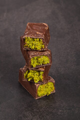 Dubai chocolate candy with crispy kataifi and pistachio paste. Dark background. Close up	