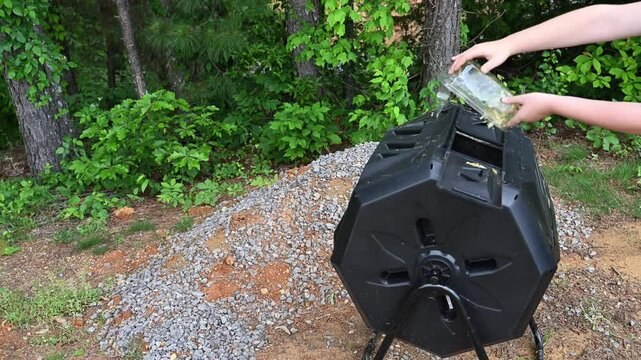 Child adding compost to a tumbling composter