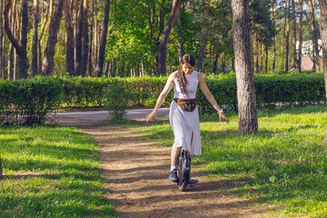 Woman in white dress on monowheel in park in Kyiv © Alexandra Lande