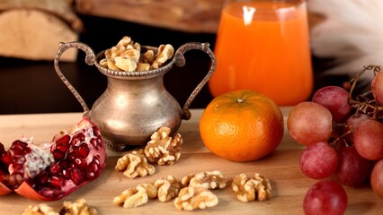 Rustic setup of walnuts, fresh fruits, orange juice, showcasing nutritious, natural snack options, ideal for promoting wellness, organic food choices, health-conscious content.