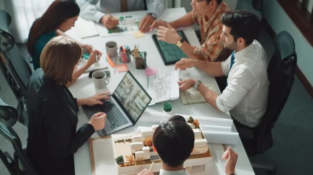 Top down view of skilled engineer team compare between blueprint and house plan. Aerial view of group of architect or designer discussing and point note to brainstorm about blueprint. Alimentation.