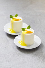 Lemon cream pudding with lemon sauce, cylindrical shape. Close-up	