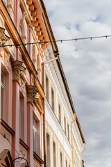 A charming European street lined with pastel-colored historic buildings, ornate architectural details, and a nostalgic atmosphere under a soft daylight sky