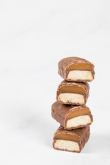 Chocolate bar with caramel and cookiein. White background. Copy space