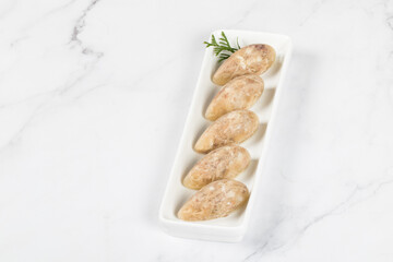 Homemade Jellied meat in the shape of a quenelle. On a plate. White background. Close up