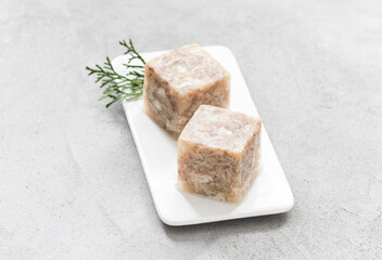 Homemade Jellied Meat in the shape of a cube. On a plate