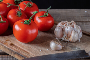 Tomatoes and garlic for the preparation of sauce in a rustic setting.