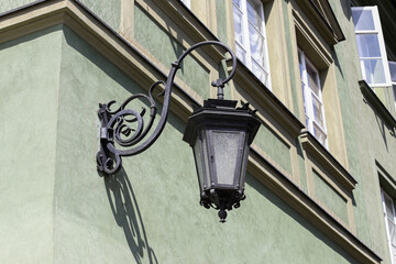 Old metal street lamp. Decorative black lantern. Historic vintage style. Elegant iron details. City...