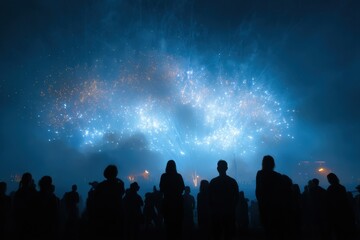 Silhouetted crowd watches vibrant fireworks display under a starry night sky.