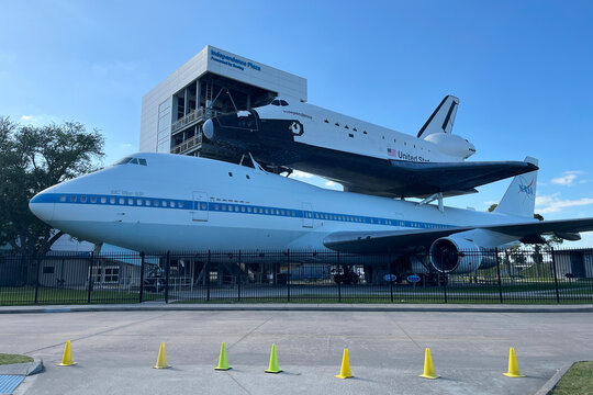 Houston, TX, USA - Apr 14, 2025: A space shuttle replica mounted on the historic and original NASA 905 shuttle carrier aircraft (SCA), displayed at Space Center Houston's Independence Plaza.