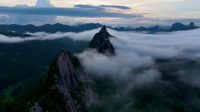 Aerial Tilt-Down into Cloud-Filled Valley with Needle-Sharp Peaks