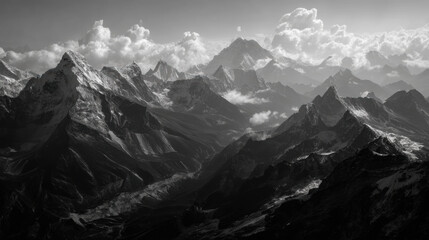 Obraz premium An ethereal grayscale landscape showcases majestic mountains piercing through a dramatic cloudscape creating a serene and awe-inspi vista of natural beauty.