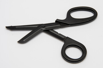 Black medical scissors with a blunt end on a white background - a professional emergency tool.
