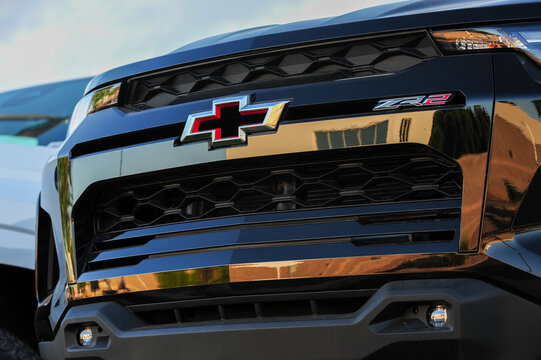 Close-up of a Chevrolet ZR2 front grille features the red-accented bowtie emblem and rugged styling, showcasing the off-road model branding sold at commercial auto dealerships.
