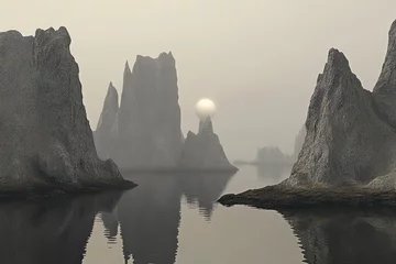 Misty, serene landscape of towering rock formations reflecting in a calm body of water at sunrise.  Gray rocks and fog create a tranquil, almost ethereal atmosphere