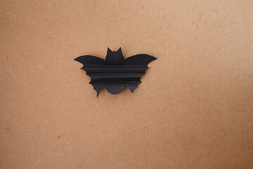 Flat lay of completed paper bat showing scalloped wings and defined silhouette with pointed ears,...