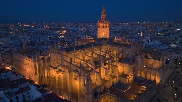 Gothic Cathedral of Seville at Night, Aerial Shot with Giralda bell tower in Seville Old town in Andalusia, Spain.