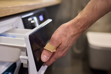 A person is effortlessly using their hand to open the drawer of a contemporary modern refrigerator