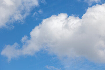 White cumulus clouds are creating a beautiful scene in the vast blue sky