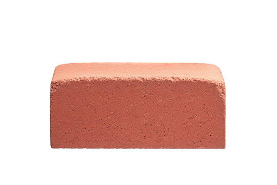 A red brick isolated on a black background is lit on the front and top surface