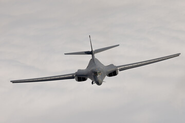 Frontal  view of a B-1 Lancer  over clouds, with wings full forward
