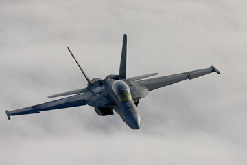 Frontal view of a F/A-18F Super Hornet  over clouds