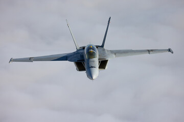 Frontal view of a F/A-18F Super Hornet  over clouds