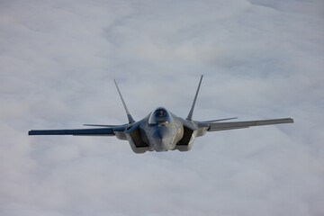 Very  close frontal view of a F-35C Lightning II   over clouds