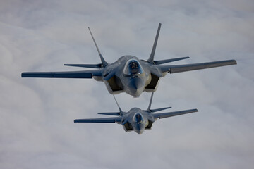 Very  close top view of a pair of F-35C Lightning II   over clouds