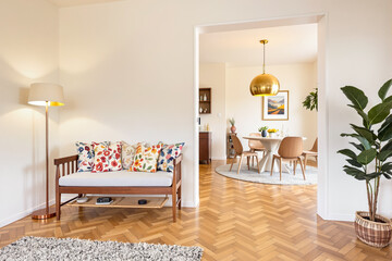 wooden bench with colorful floral pillows in a bright living room