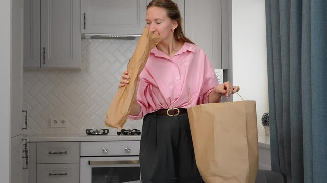 Woman unpacking groceries at home after shopping in supermarket buying food. Satisfied young online marketplace shopper unpacking a box of products ordered online with courier delivery