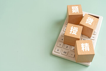 顕微授精と書かれたブロックと電卓