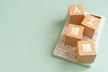 人工授精と書かれたブロックと電卓