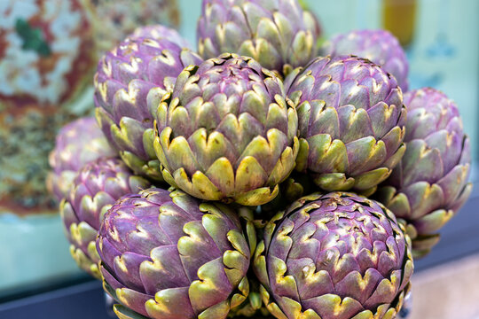Fresh purple artichokes arranged in a basket at a local market showcasing seasonal produce