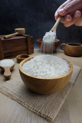 White Rice in Wooden Bowl with Wooden Spoon on Rustic Table