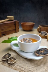 Herbal Tea with Dried Citrus in White Cup and Wooden Utensils