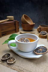 Herbal Tea with Dried Citrus in White Cup and Wooden Utensils