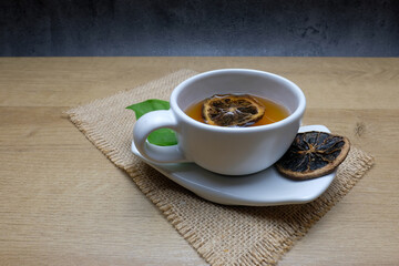 Herbal Tea with Dried Citrus in White Cup and Wooden Utensils