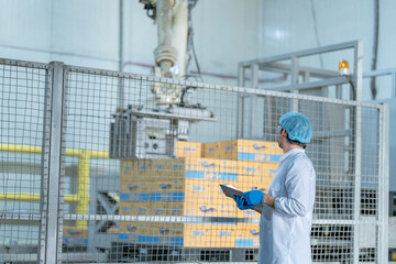 A quality control specialist in a modern factory inspects production processes while recording data...