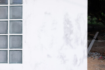Skim coat on concrete wall for flat smooth. Include glass block brick wall. To plaster or apply white compound mortar cement material on surface for repair, improvement by builder professional.