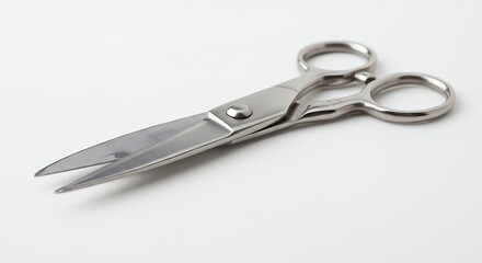 Obraz premium Pair of metal scissors against white background