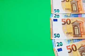 Twenty and fifty euro bills on a green background