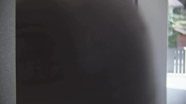 LD Man placing finger onto biometric door lock and entering the house