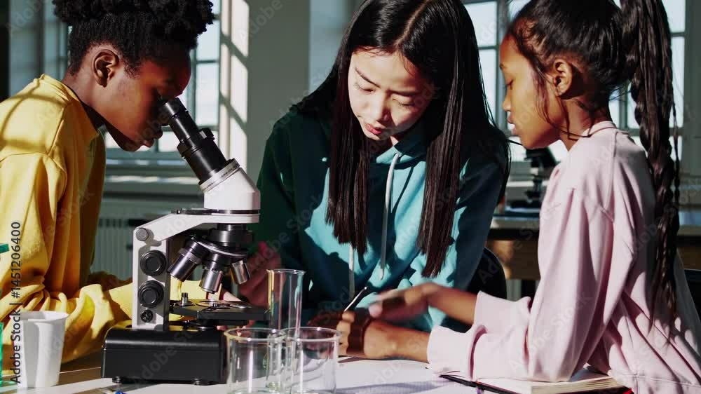 Poster three students in hoodies engage in a science experiment with a microscope. shot from a side angle, 