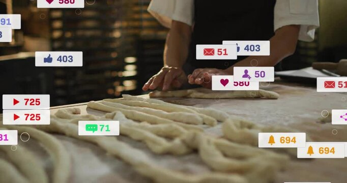 Female baker shaping twisted dough on wooden counter in bakery, with floating social icons